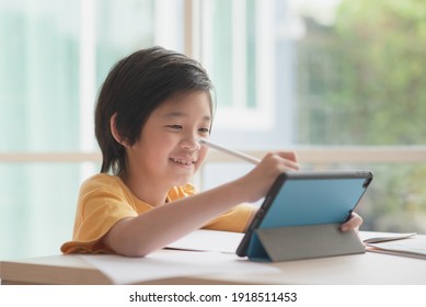 Asian Child Drawing Picture With Digital Pen On Tablet