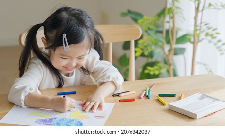 Asian Child Drawing Pictures At Home