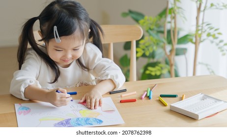 Asian child drawing pictures at home