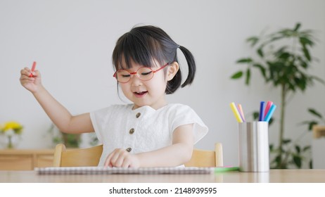 Asian Child Drawing In The Room