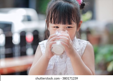 Asian child drinking milk at home, soft focus