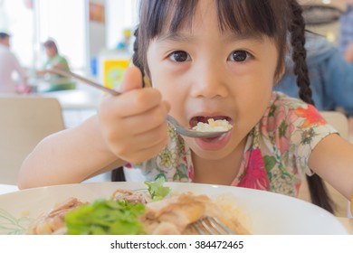 Asian Child Eat In The Food Court