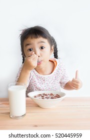 Asian Child Is Eating Cereal With Milk With Happily