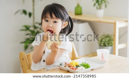 Asian child eating in the living room