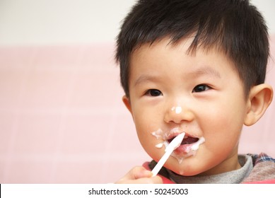 Asian Child Eating Yogurt