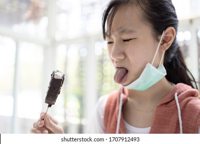 Asian Child Girl Eating Ice Cream,have Sense Of Taste Problems With Taste Receptor,no Appetite,anorexia,disgust With Tongue Out Of Mouth,bad Taste,don't Extract Any Flavor,sad Woman Bored With Food