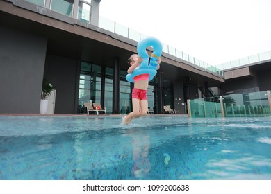 Asian Child Girl Has Fun And Jumping In The Pool.