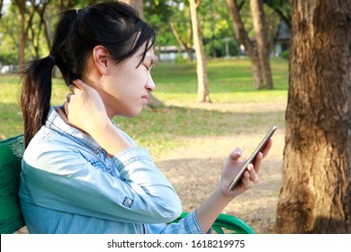 Asian Child Girl Has Neck Pain,massage Her Neck,bending Head While Playing The Mobile Phone For A Long Time,stiff Neck,muscles Pain,incorrect Posture In Use Phone,female People Suffer From Nomophobia 