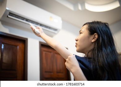 Asian Child Girl Holding A Remote Control,turn On The Air Conditioner,adjust The Temperature To Cool To Cool Down The Heat,feels Faint,hot Uncomfortable After Going Outside Outdoors,hot Strong Sunburn