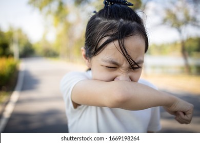 Asian Child Girl Sneezing,coughing Into Her Arm Or Elbow To Prevent Spread Covid-19,Coronavirus,avoid Sneeze On Hand,sick Woman Covering Nose And Mouth With Her Arm From Dusty,allergies,air Pollution 