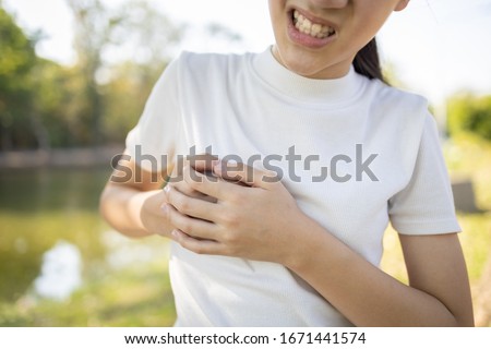 Asian child girl touching her breasts sore with severe pain in her chest,teenage girl feel menstrual breast pain,hormonal or growth in to adolescents cause irritation,painful engorgement to the breast