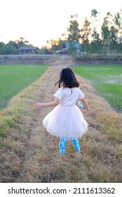 Asian Child Girl Is Turn Around In The Field. 