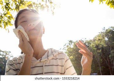 Asian Child Girl Wiping Sweat On Her Face With Tissue Paper Suffer From Sunburn Very Hot In Summer Weather Problem Feel Faint, Tired Female Teenage With Heat Stroke,high Temperature On Sunny Day