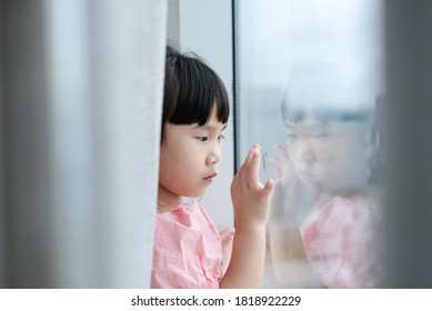 Asian child girl writing in the mirror and her finger