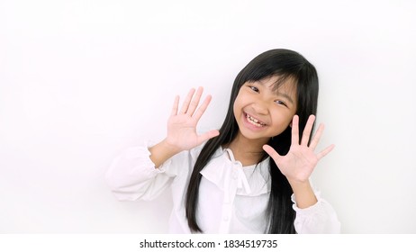 Asian Child Girls Are Smiling Cute And Showing Ten Fingers On A White Background.