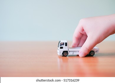 A Asian Child Hand Holding Toy White Car Truck In Hand On White Background With Copyspace, Learning And Education Background Concept