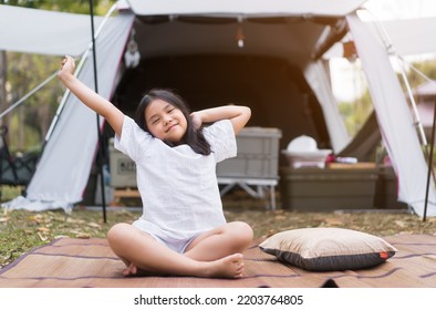 Asian Child Happy Or Kid Girl Camper Wake Up To Sit Stretch Oneself On Mat And Grass Lawn On Nature Camping Tent And Morning By White Cabin Camp On Autumn Forest Campground And Holiday Vacation Relax