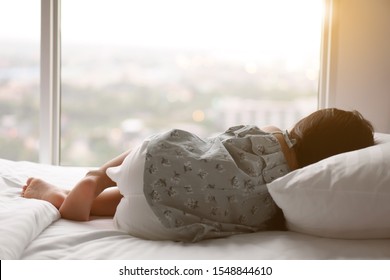 Asian Child Or Kid Girl Sleeping Alone And Lonely Depress Or Comfortably And Sweet Dream For Relax On White Bed And Pillow In Bedroom At Home With Morning Warm Sunlight On Window And Wake Up Late