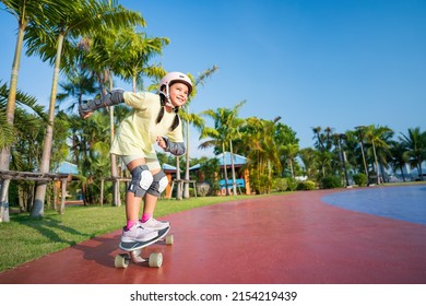 asian child or kid girl smile playing surf skate or skateboard in skatepark and extreme sports exercise to wearing helmet elbow pads wrist and knee support for body safety protect at bang phra park - Shutterstock ID 2154219439