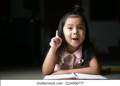 Asian Child Or Kid Girl Student Sleep Reading And Thinking For New Idea With Wow Open Mouth On Homework And Diary Or Book At Children Kindergarten Classroom Or Nursery Preschool In Home On Black Space