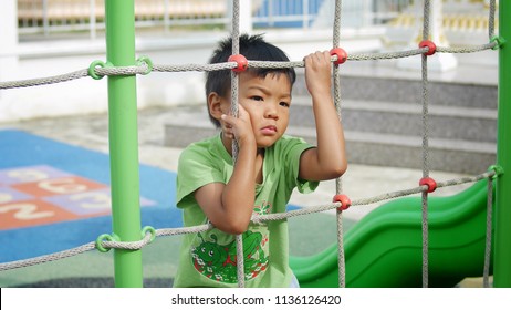 Asian Child Little Boy Standing Alone At The Playground. He Feeling Sad And Stressed. 