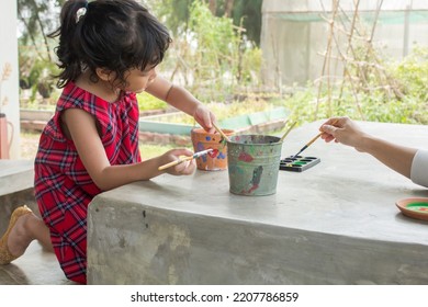 Asian Child Painting Color On Pot Outdoor