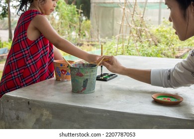 Asian Child Painting Color On Pot Outdoor