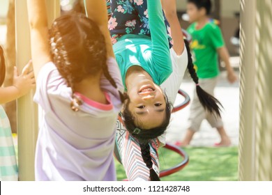 Asian Child Play The Monkey Bars In The Playground