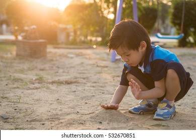 Asian Child Playing With Sand In The Playground