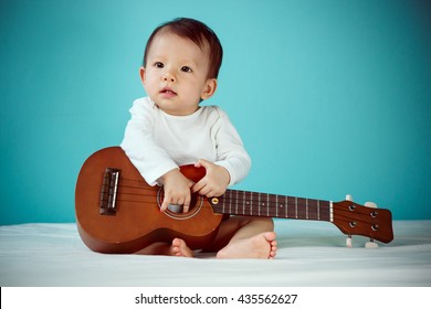 Asian child playing ukulele