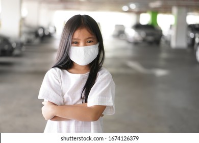 Asian Child Positive Or Kid Girl Smiling Wear N95 Cloth Face Mask For Close Mouth And Sick On Nose With Cold Cough And Protect PM2.5 Dust Or Influenza Virus And Bacteria From Smoke And Crossed Arms