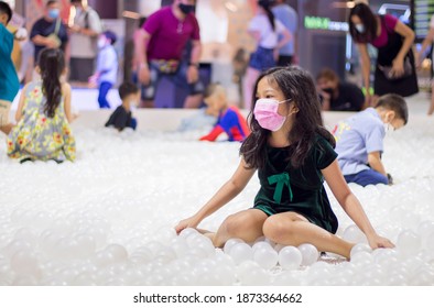 Asian Child In Public Pool Of White Ball For Covid Protection 