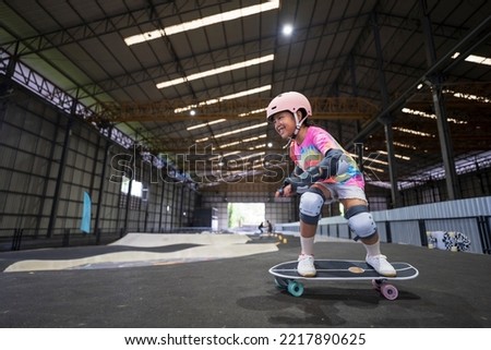 asian child skater or kid girl fun playing skateboard or smile ride surf skate on pump track in school skate park by extreme sports surfing to wearing helmet elbow wrist knee support for body safety