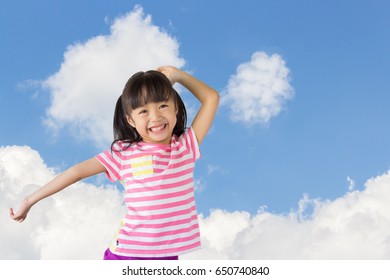 asian child smile happily with blue sky and clouds as background