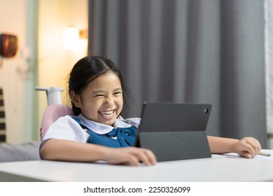 asian child smile learning on computer tablet or kid girl student laughing fun to studying online class or person wear school uniform happy learn from home and back to school by video call education - Powered by Shutterstock