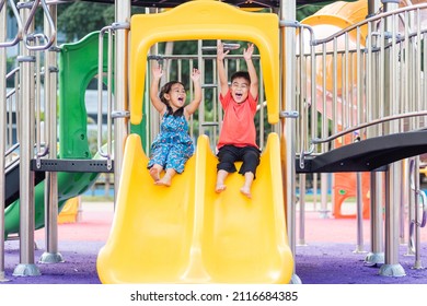 Asian child smiling playing on slider bar toy outdoor playground, happy preschool little kid having funny while playing on the playground equipment in the daytime in summer, Little girl boy climbing - Shutterstock ID 2116684385