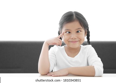 Asian Child Strabismus Or Kid Girl Squint Lazy Eye And Amblyopia Think With Finger Point Brain Head For New Idea And Imagination Or Creativity Education With Smile Happy At Nursery Pre School On White