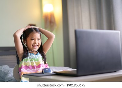 Asian Child Student Or Kid Girl Smile Enjoy E-learning On Computer Notebook With Wearing Headphone For Communication And Study Online Or Learn From Home To Play Laptop For Education By Back To School