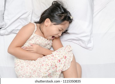 Asian Child Suffering From Stomachache And Lying On Bed. Diarrhea Or Healthy Concept