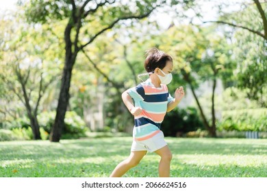 Asian Child Toddler Boy Playing Running On Green Meadow Lawn Playground In Outdoor Park.Sport Healthcare Child With Mask Exercise Run At Home.Activity Outdoor.School Kid Free To Run.Freedom Motivation