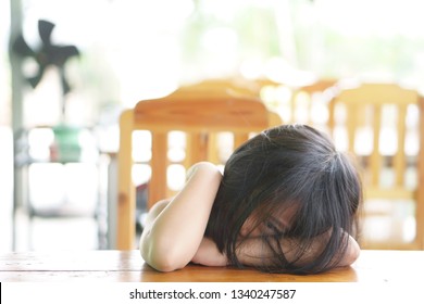 Asian Child Touchy Or Kid Girl Sleeping And Angry Cry With Sad Or Sick On Wood Table At Nursery Or Kindergarten And Preschool Restaurant