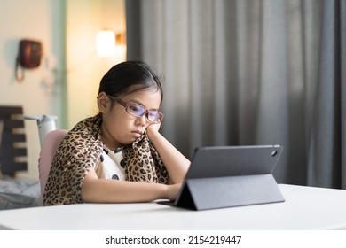 Asian Child Unhappy Bored Video Call Learning And Study Online Class On Computer Tablet Or Kid Girl Student Wearing Blue Block Eyeglasses For Eye Protection Or Person Stressed Learn From Home School