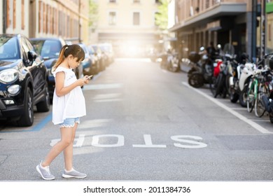Asian Child is watching the phone on the road crossing or using a mobile phone for a long time hurts her eyes and has an aggressive atmosphere. Concept danger for children's mobile phones. - Powered by Shutterstock