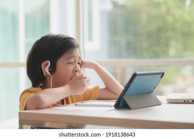 Asian Child Is Yawning And Bored While Studying Online At Home