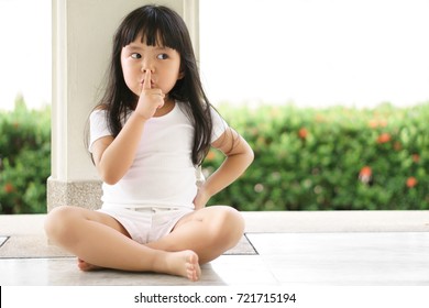 Asian Children Cute Or Kid Girl Squat And Forefinger Close Mouth For Tell Quietly And Secret Surprise With Play Hide And Seek At Back Pole With Space