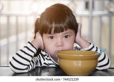 Asian Children Cute Or Kid Girl Student Anorexia Or Sad With Vacant And Prop Up Or Hand To Cheek On Food Table For Breakfast Before Going To School For Study With Warm Sunlight