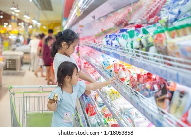 Asian Children Girl  On The Cart Shopping Choose To See Fresh Food In Department Store.