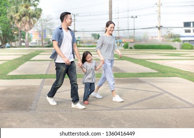 Asian Children And Her Parent Relax In Public Garden, They Holding Hand And Walk In Family Time, Family Happiness Activity