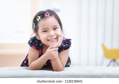 Asian Children Or Kid Girl And Student Thinking For New Idea And Happy Fun Or Smile White Teeth And Hand To Cheek With Stick Hairpin At Kindergarten Classroom Or Nursery And Child Hospital Or School