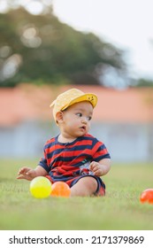 Asian Children Playing Ball In The Middle Of The Lawn